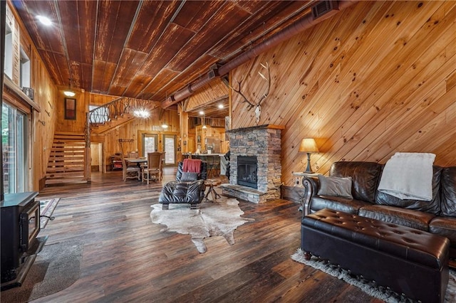 living room featuring wood walls, a wood stove, a stone fireplace, dark hardwood / wood-style flooring, and wood ceiling