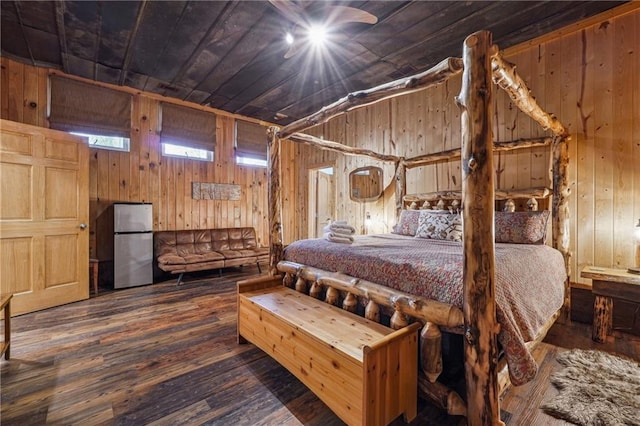 bedroom featuring stainless steel fridge, dark wood-type flooring, and wood walls