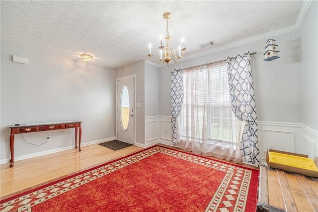 901 Elijah Way, Bethlehem, GA 30620 - foyer entrance featuring wood finished floors, a chandelier, a textured ceiling, wainscoting, and a decorative wall