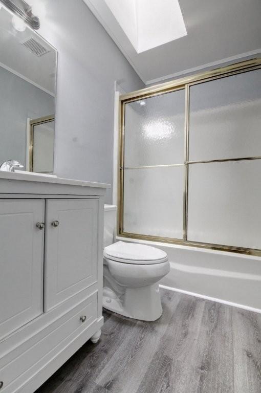2773 Hawk Trace Ct NE, Marietta, GA 30066 - bathroom featuring wood finished floors, a skylight, vanity, and shower / bath combination with glass door