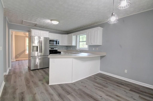 2773 Hawk Trace Ct NE, Marietta, GA 30066 - kitchen with stainless steel appliances, a textured ceiling, light countertops, wood finished floors, and a peninsula