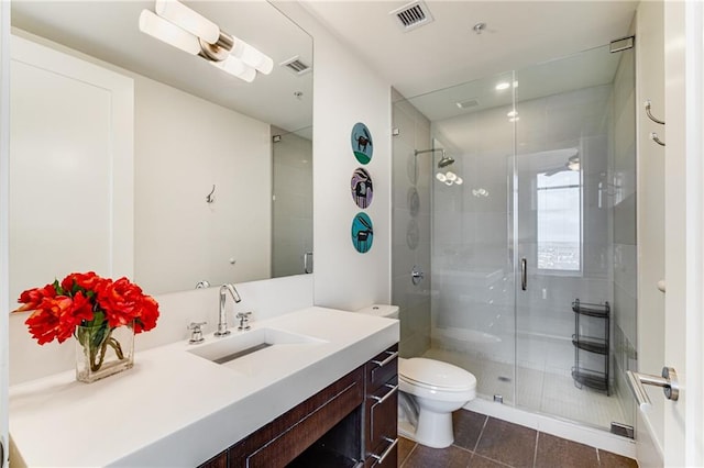 bathroom featuring tile patterned flooring, an enclosed shower, vanity, and toilet