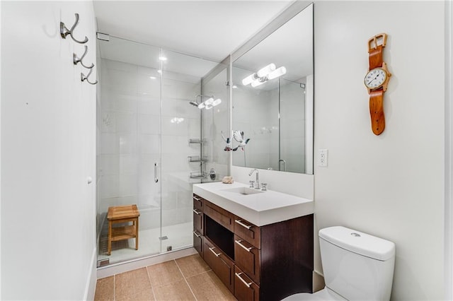 bathroom with toilet, vanity, tile patterned flooring, and a shower with shower door