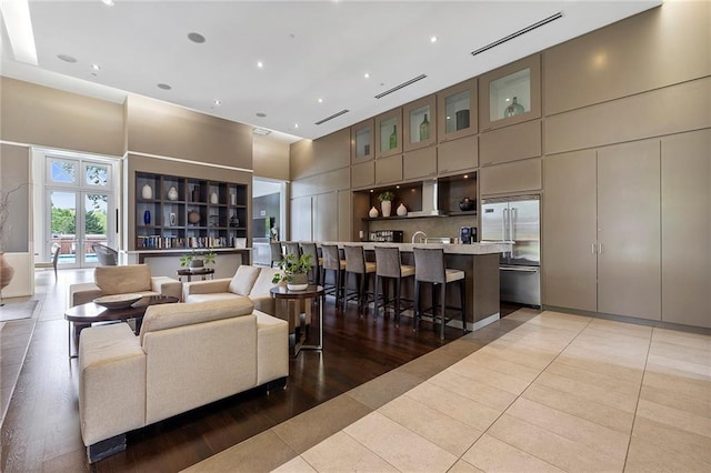 tiled living room with french doors and a towering ceiling