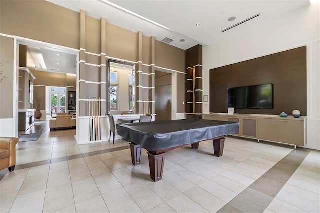 recreation room featuring a towering ceiling, billiards, and light tile patterned flooring