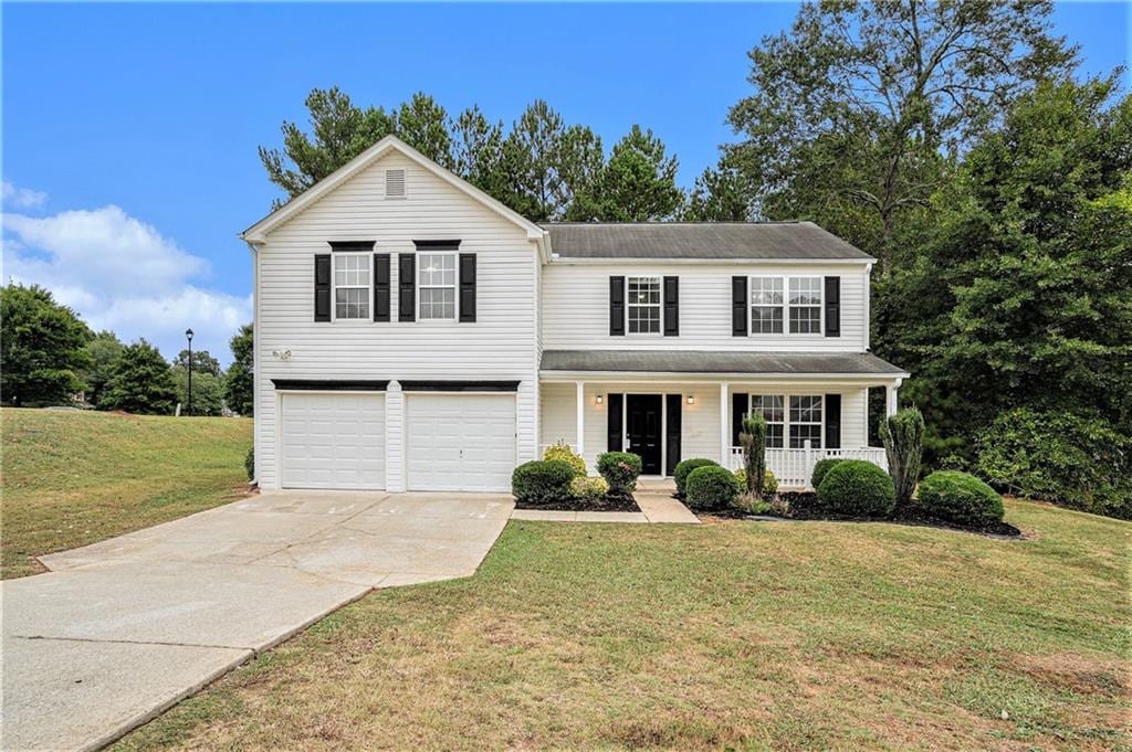 front facade with a front lawn, covered porch, and a garage