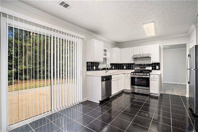 kitchen featuring crown molding, stainless steel appliances, and white cabinets