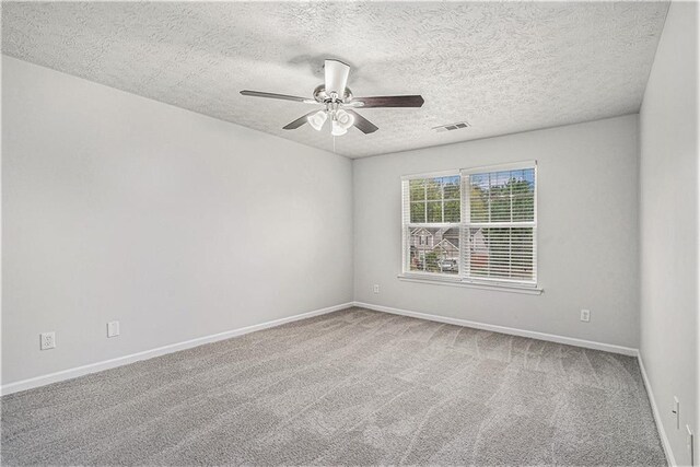 carpeted empty room featuring a textured ceiling and ceiling fan