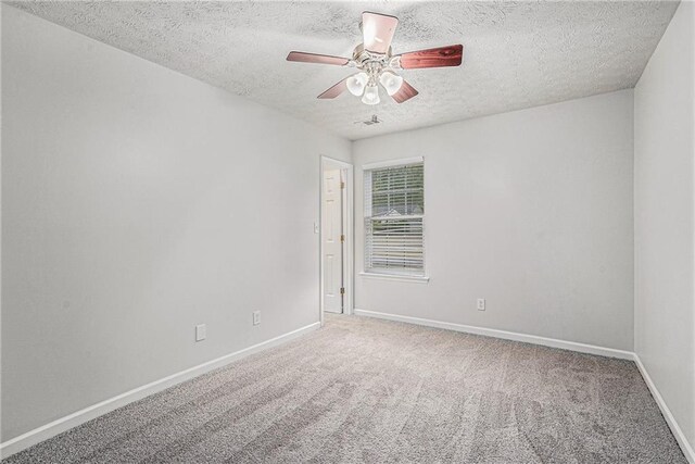 empty room with ceiling fan, a textured ceiling, and carpet