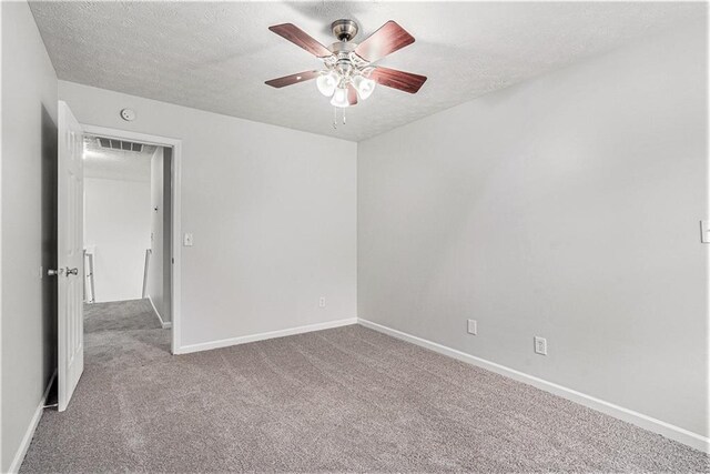 carpeted empty room featuring ceiling fan and a textured ceiling