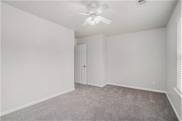 carpeted spare room featuring ceiling fan and a textured ceiling