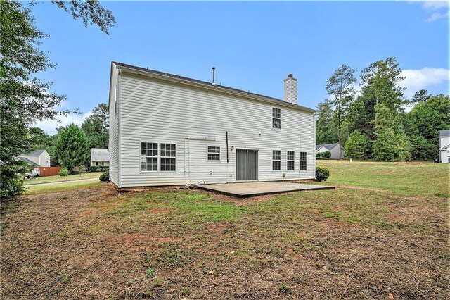 rear view of property with a lawn and a patio