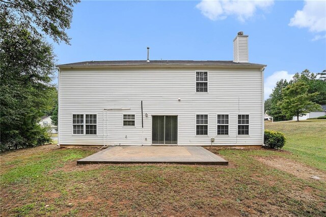 rear view of property featuring a lawn and a patio area