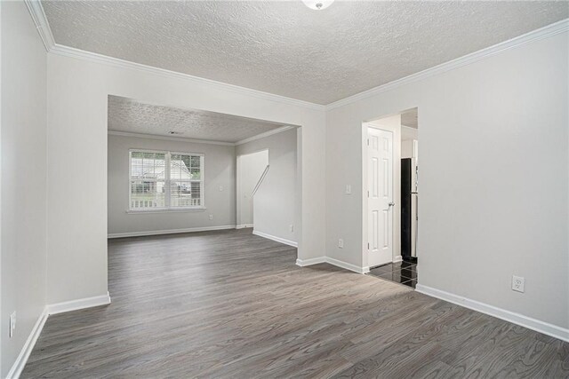 spare room featuring a textured ceiling, dark hardwood / wood-style floors, and crown molding