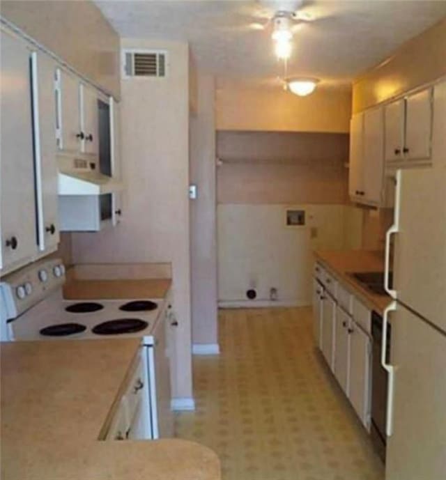 kitchen featuring white appliances, exhaust hood, visible vents, white cabinets, and light countertops