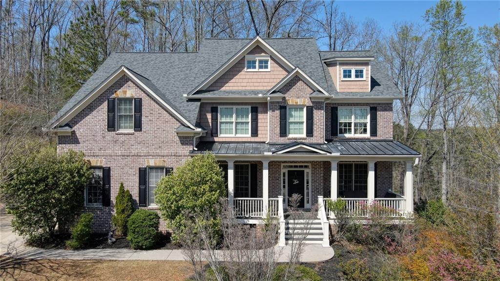 4514 Heathrow Ct NW, Kennesaw, GA 30152 - view of front of property featuring a standing seam roof, brick siding, metal roof, a shingled roof, and a porch