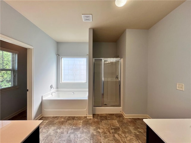 bathroom featuring vanity and independent shower and bath