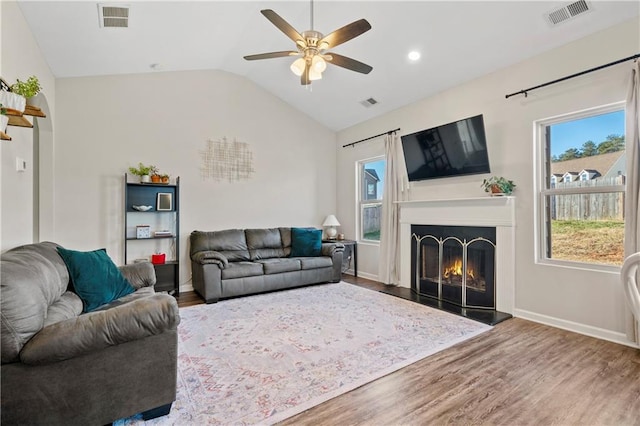 living room with ceiling fan, lofted ceiling, and wood-type flooring