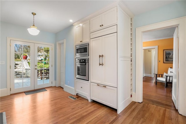 kitchen with french doors, decorative light fixtures, light wood-style floors, built in appliances, and baseboards