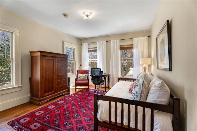 bedroom with baseboards and wood finished floors