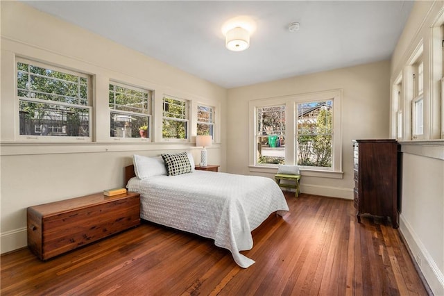 bedroom with baseboards and dark wood finished floors