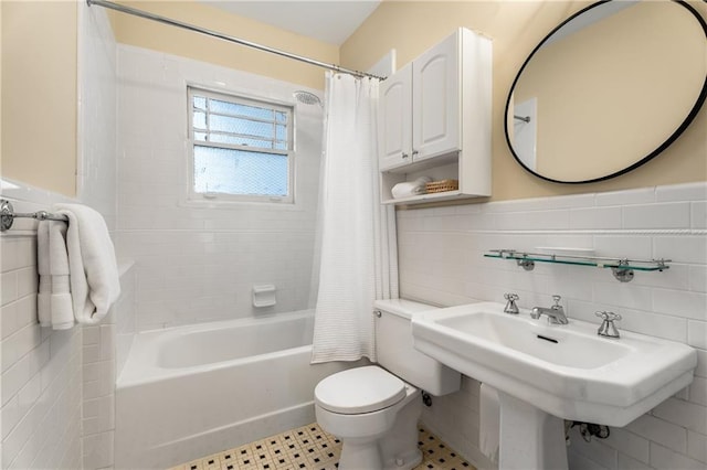 full bath with toilet, a wainscoted wall, and tile walls