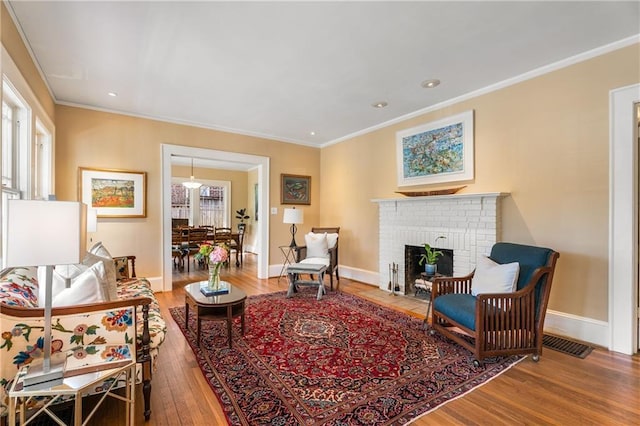 sitting room featuring baseboards, wood finished floors, and crown molding