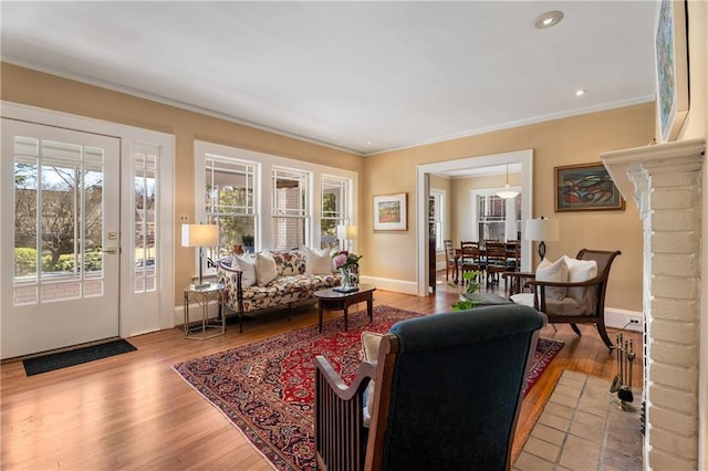 living room with ornamental molding, wood finished floors, and baseboards