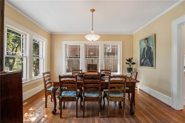 dining area featuring ornamental molding, baseboards, and wood finished floors