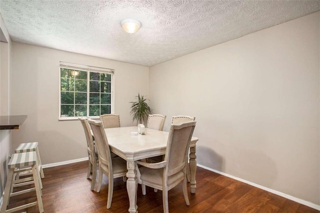 dining space with dark hardwood / wood-style flooring and a textured ceiling