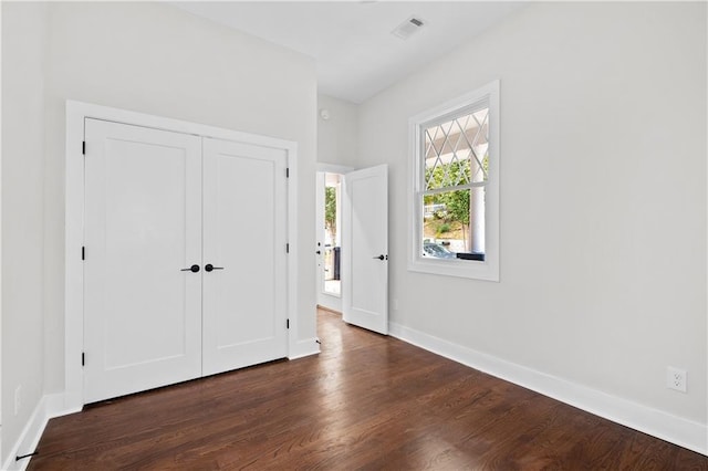 unfurnished bedroom featuring a closet and dark hardwood / wood-style floors