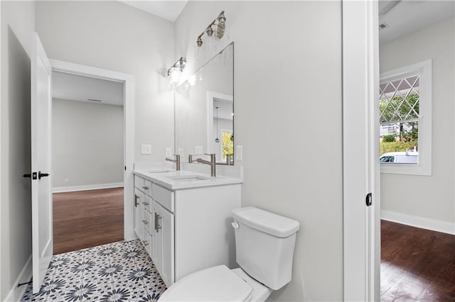 bathroom with hardwood / wood-style flooring, toilet, and vanity