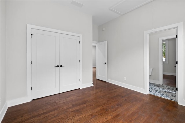 unfurnished bedroom with dark wood-type flooring and a closet