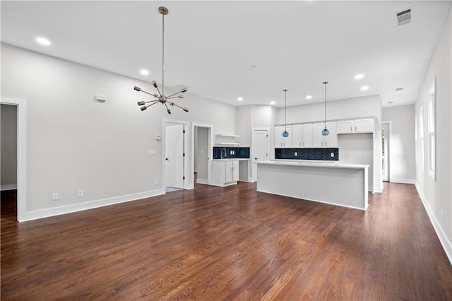 unfurnished living room with dark hardwood / wood-style flooring and a chandelier