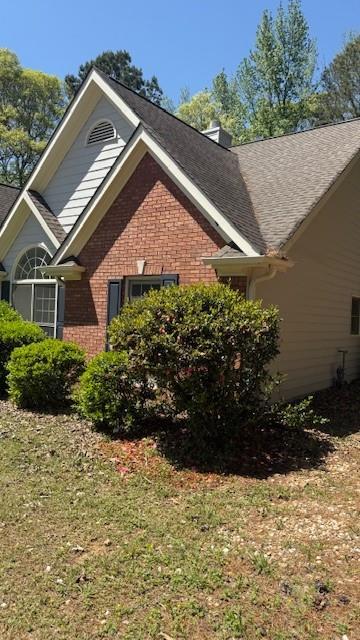 3510 Hog Mountain Rd, Dacula, GA 30019 - view of home's exterior with brick siding, a yard, and a chimney