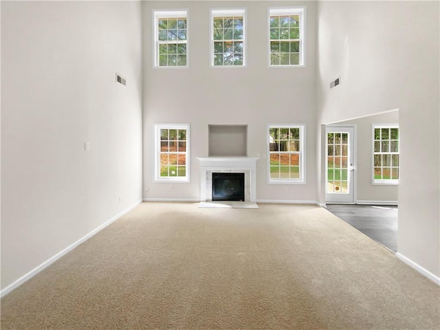 unfurnished living room featuring a high ceiling and carpet floors