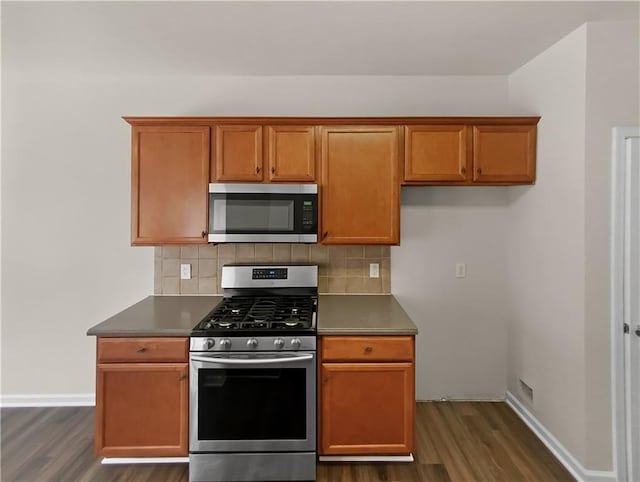 kitchen featuring decorative backsplash, stainless steel appliances, and dark hardwood / wood-style floors