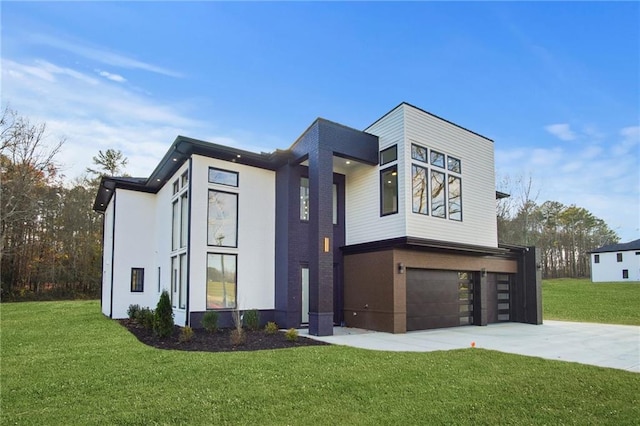 contemporary home featuring a garage, a front yard, and concrete driveway