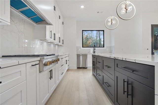 kitchen featuring decorative light fixtures, light wood-type flooring, white cabinetry, and a large island