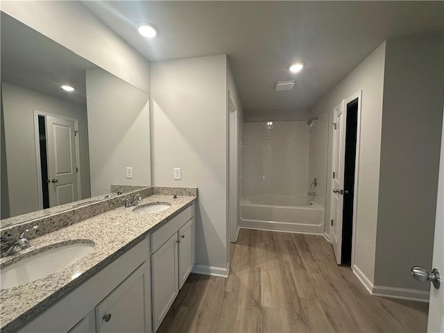 65 Emerald Ln, Covington, GA 30014 - full bathroom featuring wood finished floors, baseboards, double vanity, shower / bathtub combination, and recessed lighting