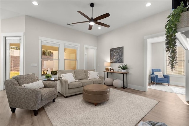 living room with ceiling fan and light wood-type flooring