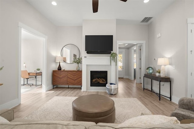 living room with ceiling fan and light wood-type flooring