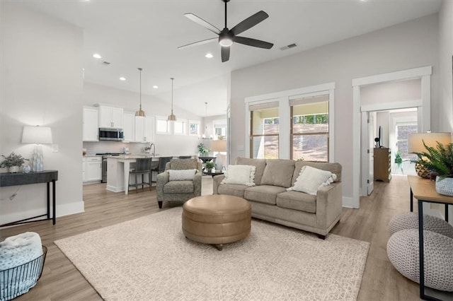 living area with recessed lighting, visible vents, light wood-style flooring, a ceiling fan, and baseboards