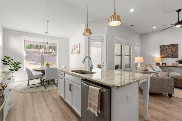 kitchen with sink, white cabinetry, light stone counters, hanging light fixtures, and dishwasher