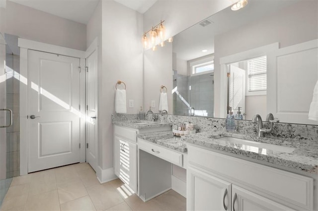 full bath with tile patterned floors, a sink, and a shower stall