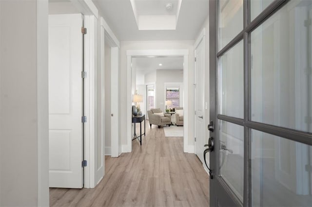 hall featuring light wood finished floors and baseboards