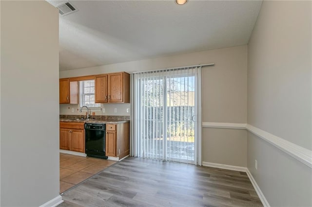 kitchen with sink, dishwasher, and light wood-type flooring