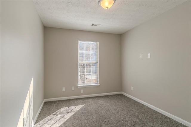 unfurnished room featuring carpet flooring and a textured ceiling