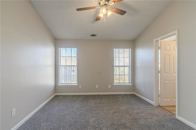 carpeted spare room featuring ceiling fan and vaulted ceiling