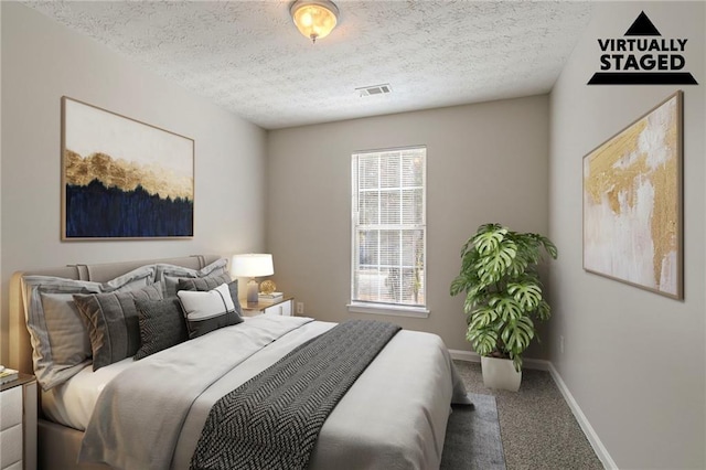 bedroom featuring carpet floors and a textured ceiling